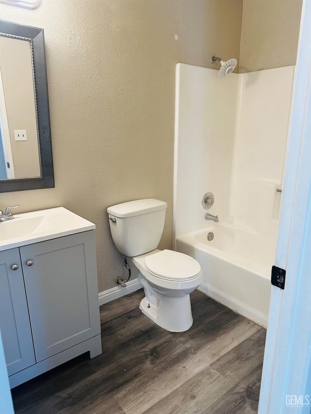 full bathroom featuring washtub / shower combination, vanity, toilet, and hardwood / wood-style floors