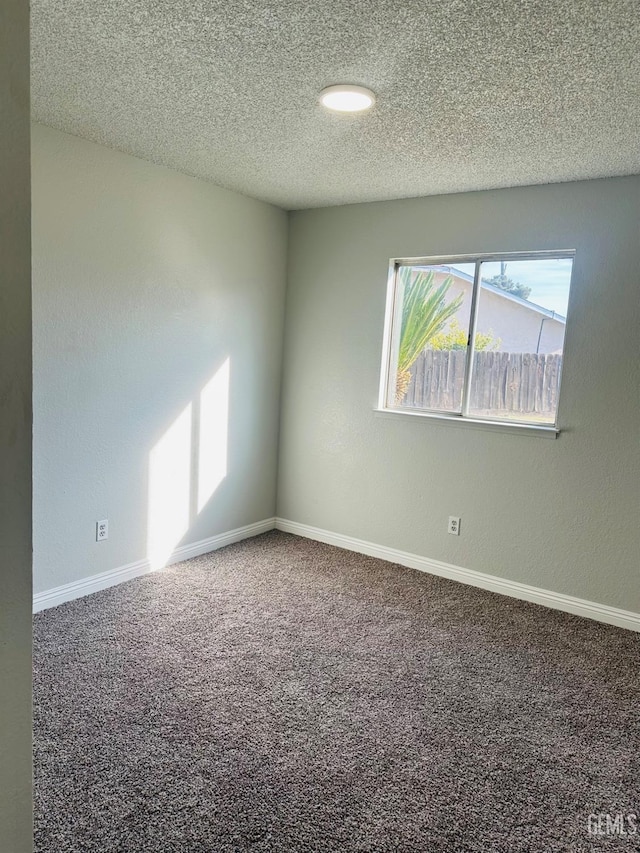 carpeted empty room with a textured ceiling