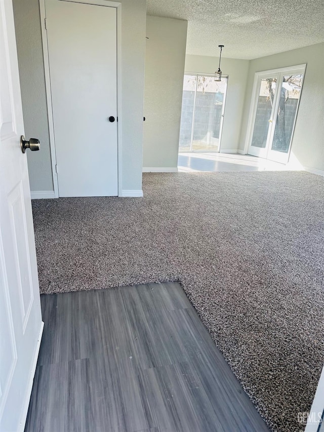 unfurnished room with dark wood-type flooring and a textured ceiling