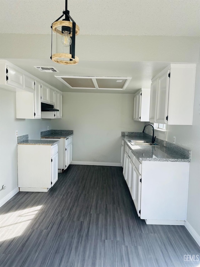 kitchen featuring pendant lighting, sink, a textured ceiling, white cabinets, and dark hardwood / wood-style flooring