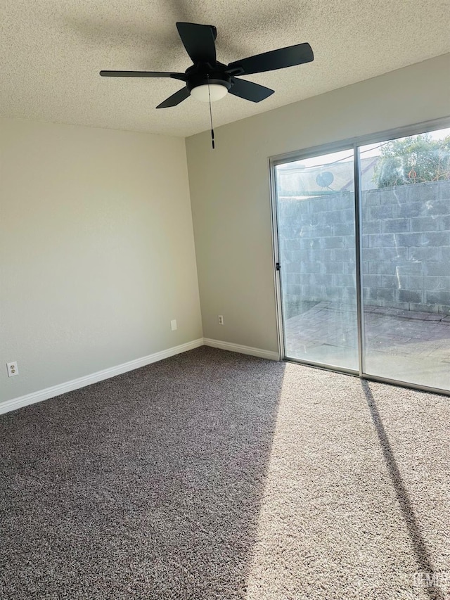 carpeted empty room featuring ceiling fan and a textured ceiling