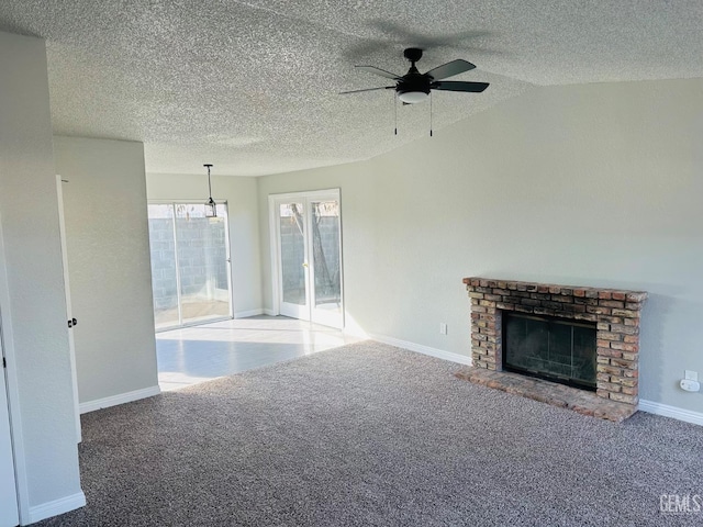 unfurnished living room featuring lofted ceiling, a brick fireplace, carpet floors, and ceiling fan