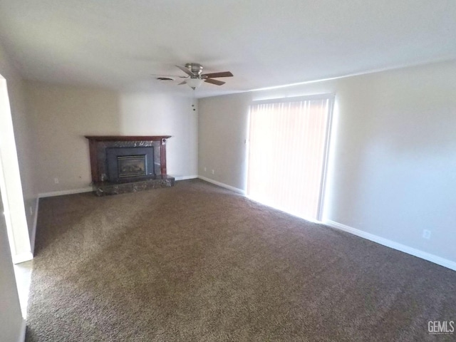 unfurnished living room with ceiling fan and dark colored carpet