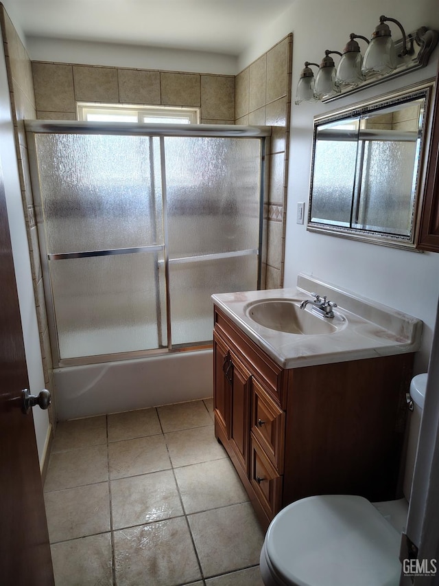 full bathroom featuring toilet, tile patterned floors, combined bath / shower with glass door, and vanity