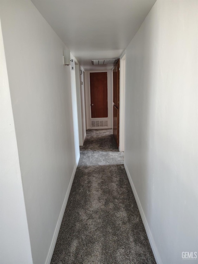 corridor with carpet floors, visible vents, and baseboards