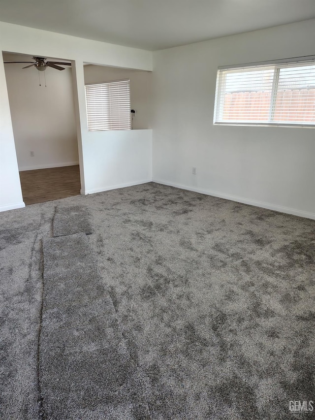 empty room featuring carpet floors, a ceiling fan, and baseboards