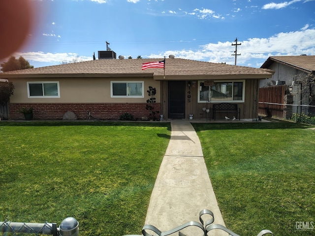 single story home featuring a front yard, brick siding, and fence