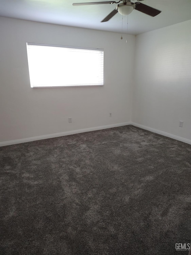 empty room featuring carpet, baseboards, and a ceiling fan