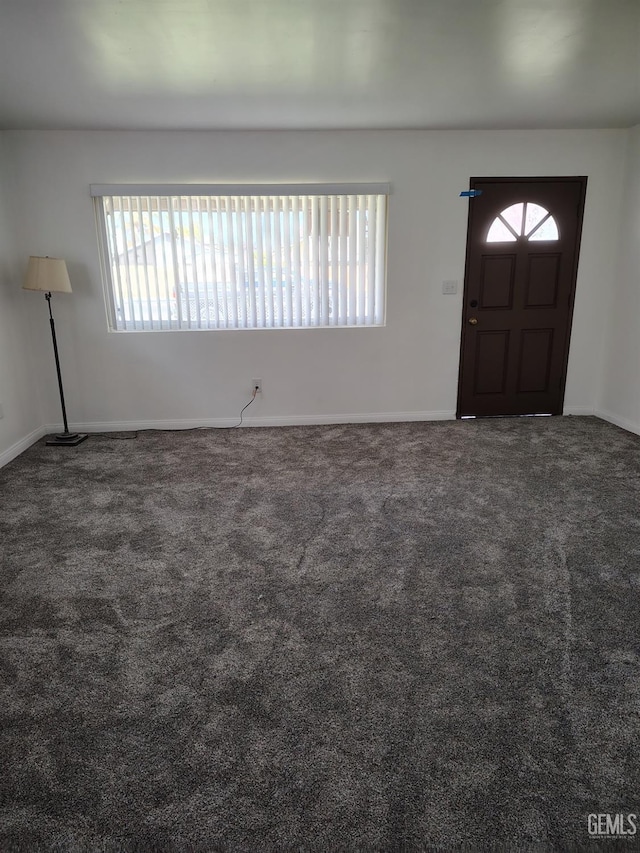 carpeted foyer with baseboards