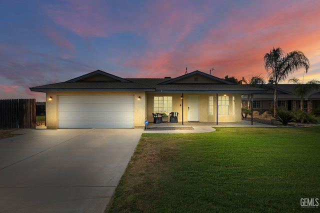 ranch-style home featuring a garage and a yard