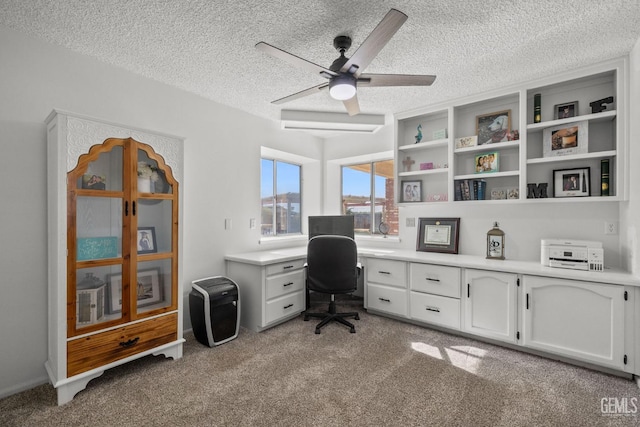 carpeted office featuring ceiling fan and a textured ceiling