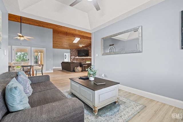 living room featuring light wood-type flooring, lofted ceiling with beams, and ceiling fan