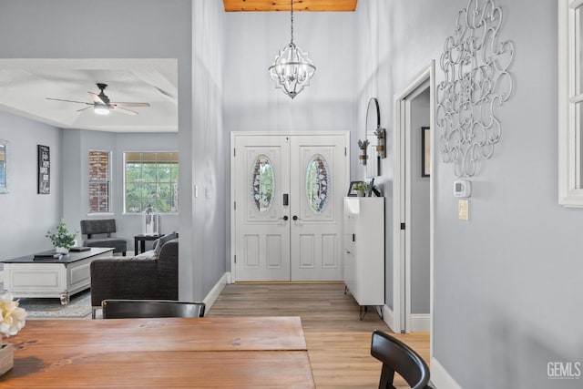 entryway featuring ceiling fan with notable chandelier and light hardwood / wood-style floors