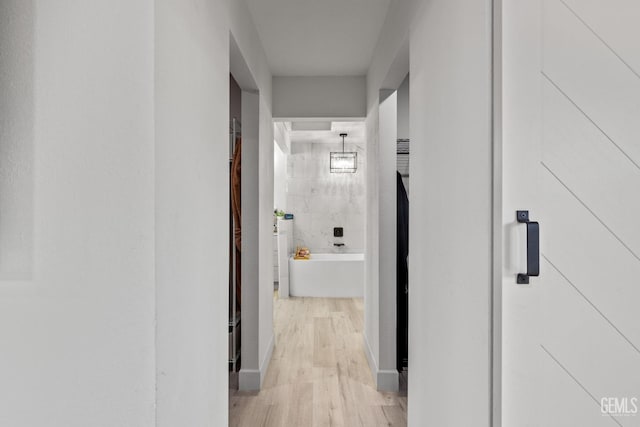 corridor with light hardwood / wood-style flooring