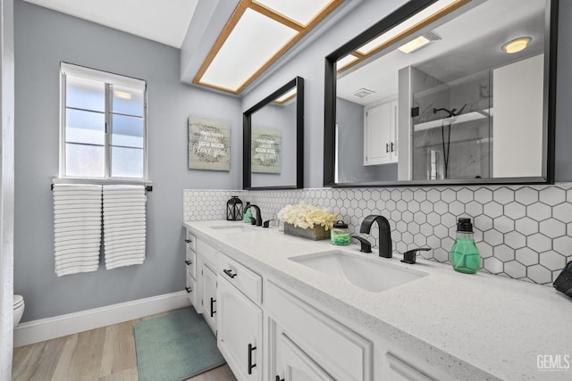 bathroom with hardwood / wood-style floors, tasteful backsplash, toilet, and vanity