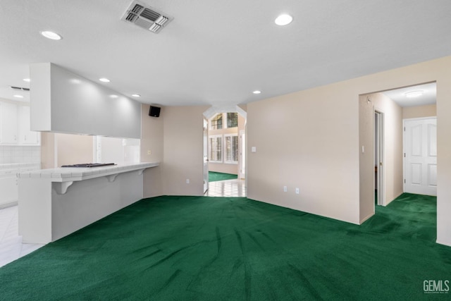 spare room with recessed lighting, light colored carpet, and visible vents