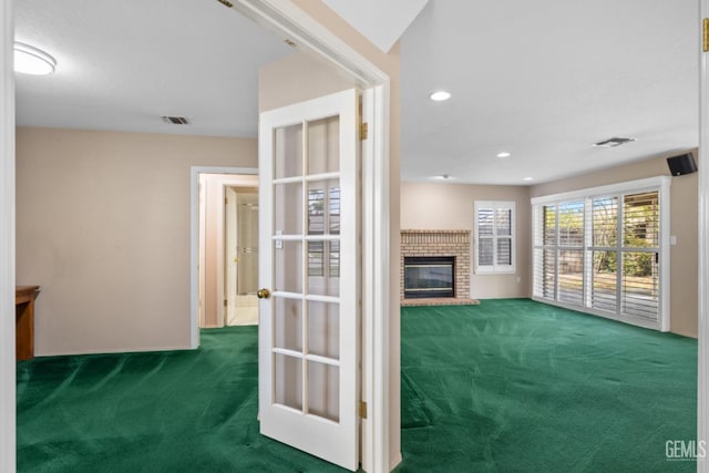 unfurnished living room featuring recessed lighting, visible vents, carpet floors, and a fireplace