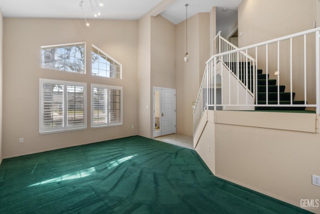 interior space with track lighting, high vaulted ceiling, and stairs