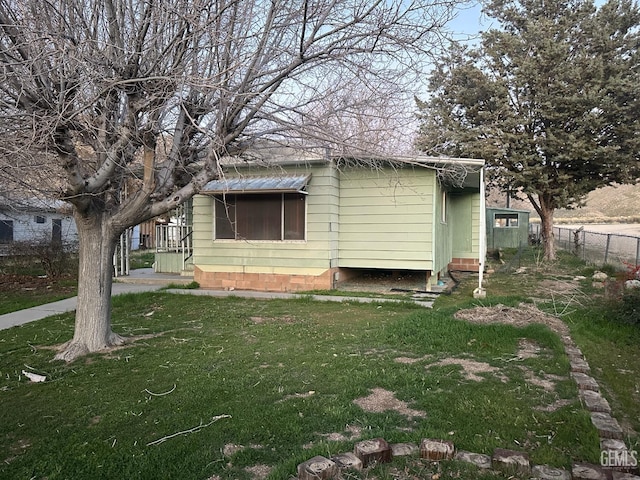 view of property exterior with fence and a yard