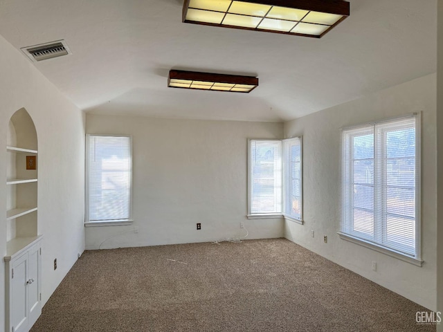 carpeted spare room with built in shelves