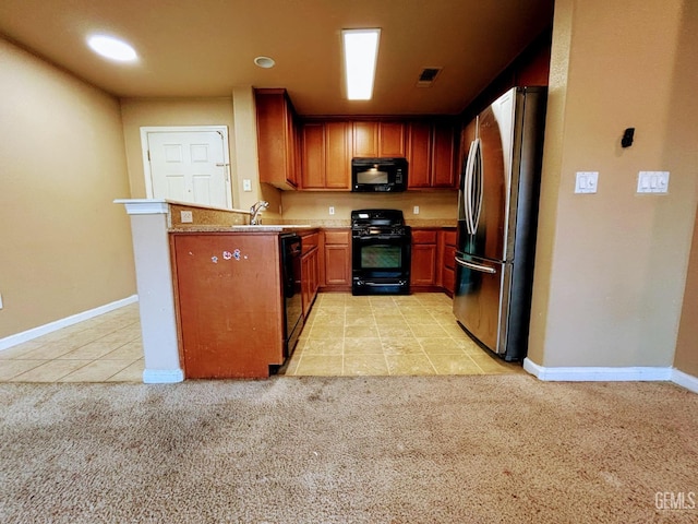 kitchen featuring sink, kitchen peninsula, black appliances, and light carpet