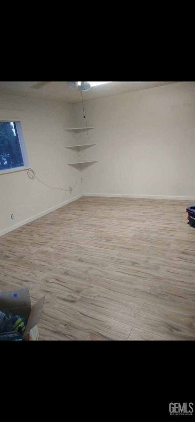 unfurnished room featuring baseboards and light wood-style floors