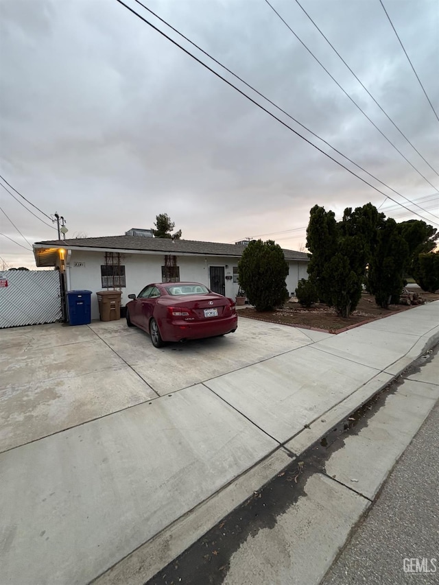 ranch-style house with concrete driveway and stucco siding