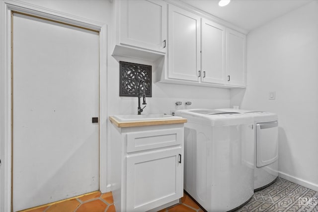 clothes washing area featuring separate washer and dryer, sink, light tile patterned floors, and cabinets