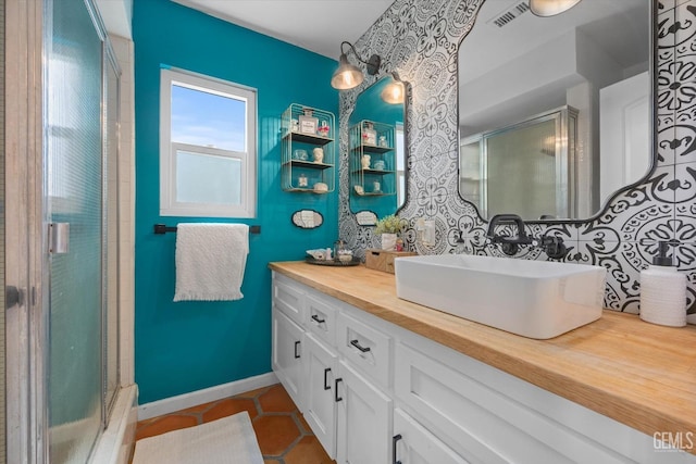 bathroom featuring vanity, tile patterned floors, and a shower with shower door