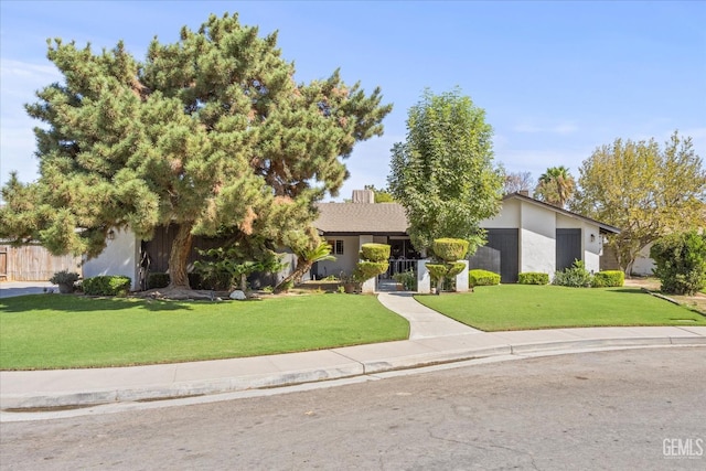 obstructed view of property featuring a front lawn