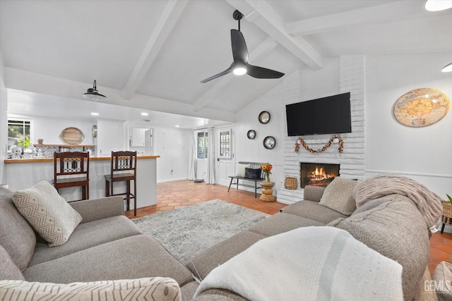 tiled living room featuring ceiling fan, a healthy amount of sunlight, a fireplace, and lofted ceiling with beams