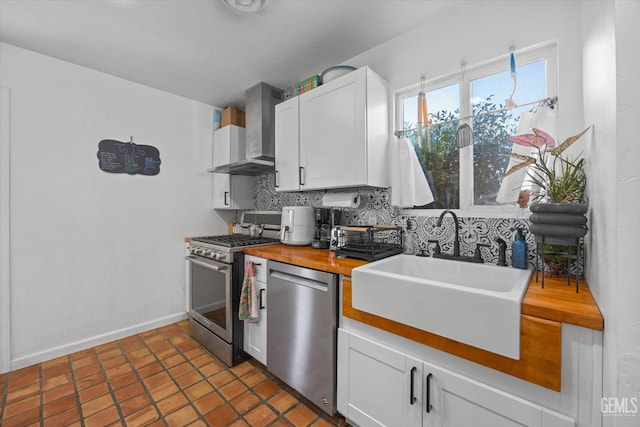 kitchen featuring white cabinetry, sink, wall chimney exhaust hood, backsplash, and appliances with stainless steel finishes