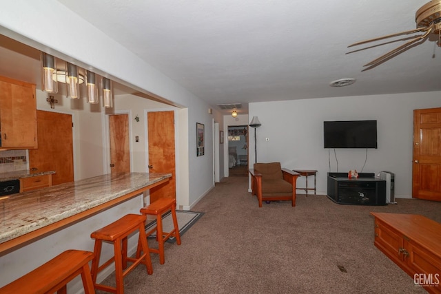 carpeted living room featuring ceiling fan and visible vents