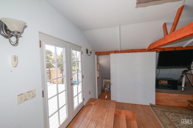 doorway to outside with wood-type flooring, french doors, and lofted ceiling