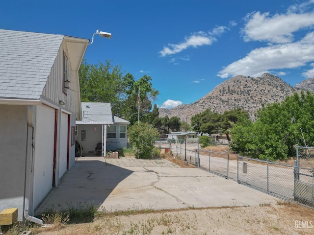 exterior space with a patio area, a mountain view, and fence
