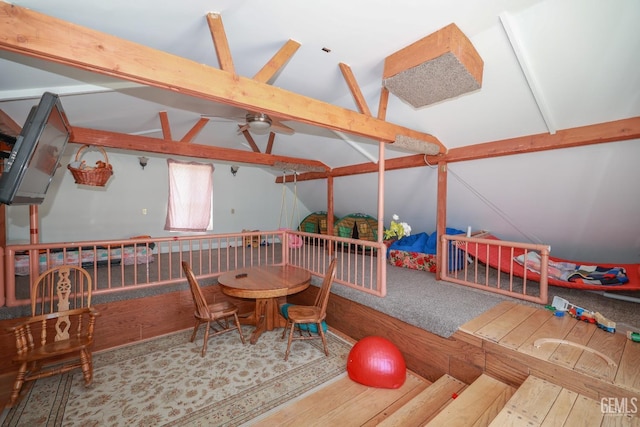recreation room featuring a ceiling fan, lofted ceiling with beams, and wood finished floors