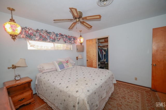 bedroom with a closet, wood finished floors, and a spacious closet