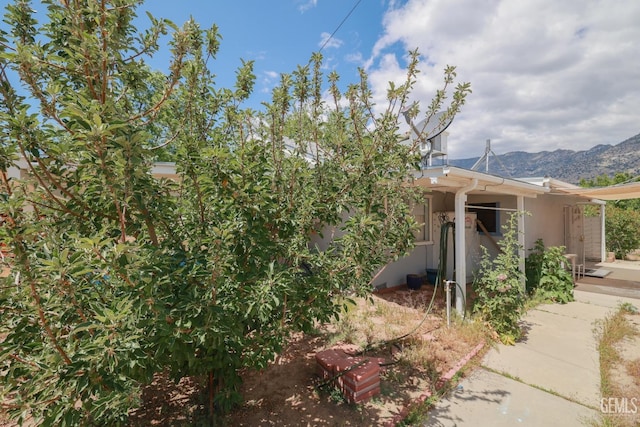 view of side of property featuring a mountain view and stucco siding