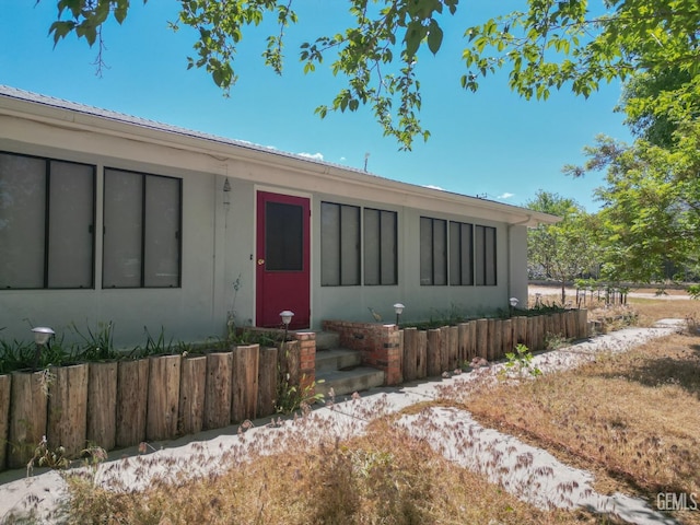 view of front facade featuring fence and metal roof