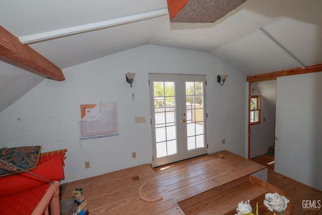 doorway featuring wood-type flooring, lofted ceiling with beams, and french doors