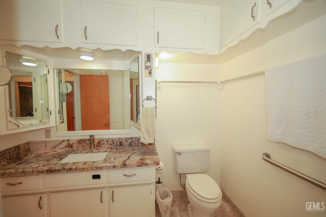 bathroom with vanity, baseboards, and toilet