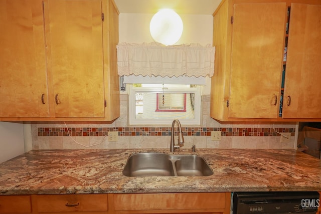 kitchen with a sink, light stone counters, tasteful backsplash, and dishwasher