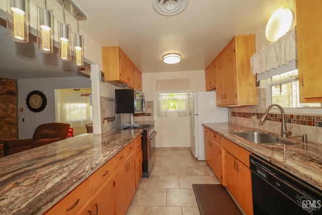 kitchen featuring decorative backsplash, stone finish flooring, appliances with stainless steel finishes, light stone countertops, and a sink
