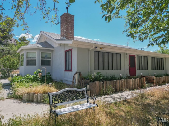 view of front of house with fence and a chimney