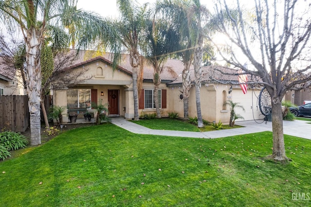 mediterranean / spanish house featuring a garage, concrete driveway, a tile roof, a front lawn, and stucco siding