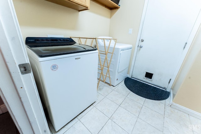 laundry area with laundry area, light tile patterned floors, and washer and clothes dryer