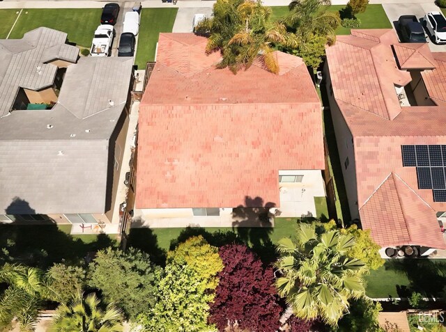 view of front facade featuring a garage, driveway, a tiled roof, and a residential view