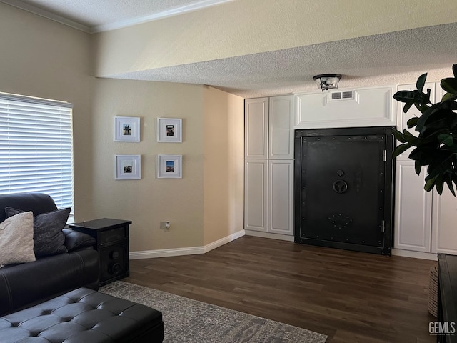living room featuring a textured ceiling, baseboards, visible vents, crown molding, and dark wood-type flooring