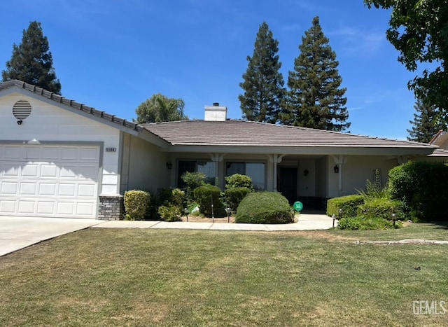 single story home with a tiled roof, a front yard, an attached garage, a chimney, and driveway