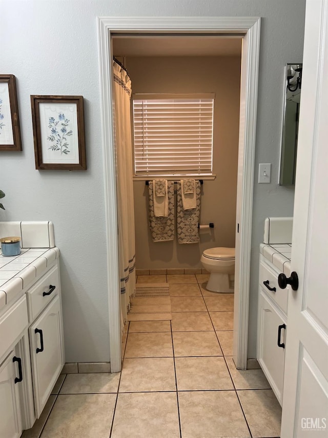 full bathroom with tile patterned floors, vanity, and toilet
